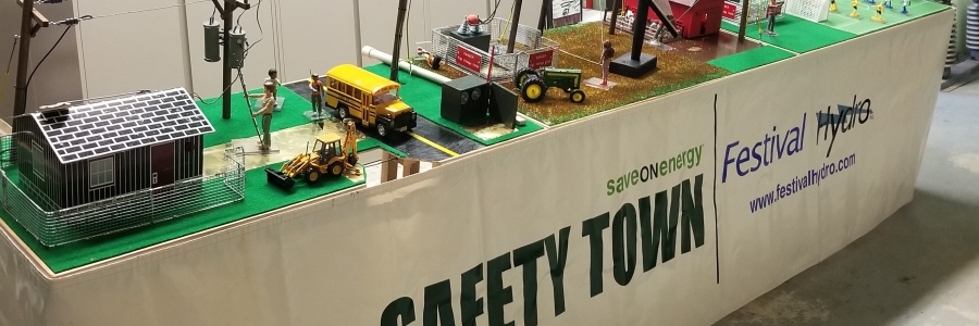 The festival hydro safety town table is displayed and shows community areas such as home, a school bus, a farm, and a park.