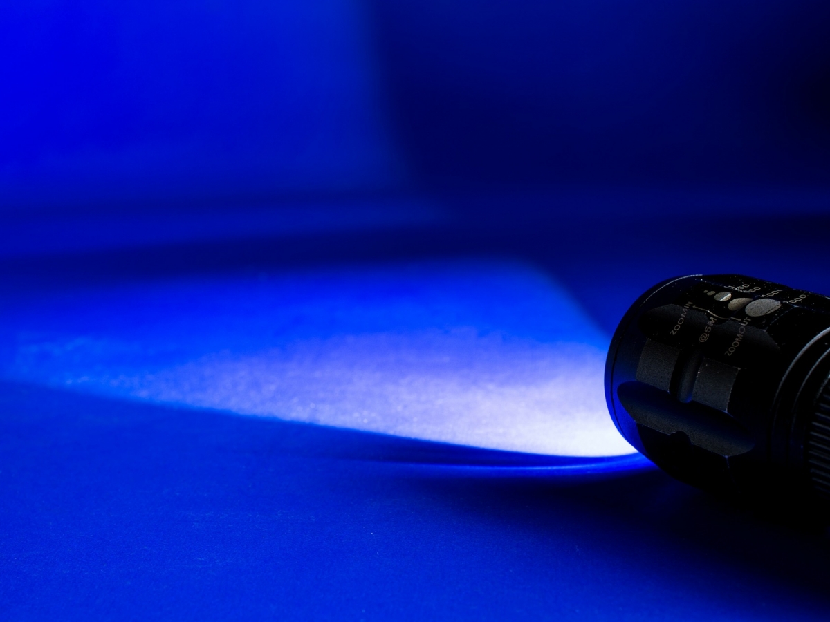 a flashlight is laying on the ground and illuminating the surroundings with a blue hue.